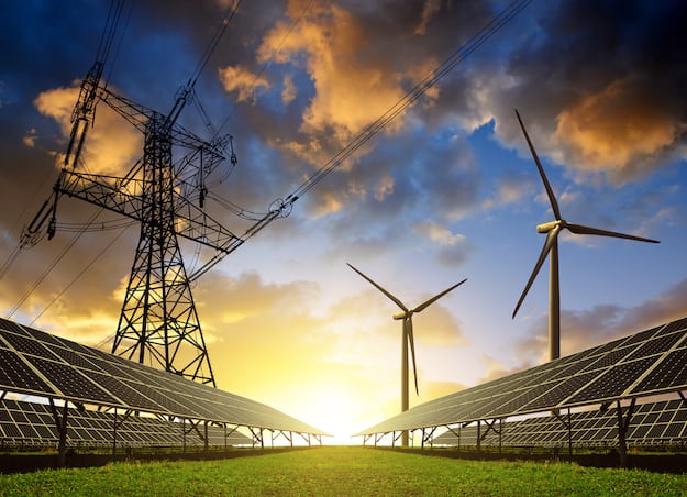 Solar panels with wind turbines and electricity pylon at sunset. Clean energy concept.