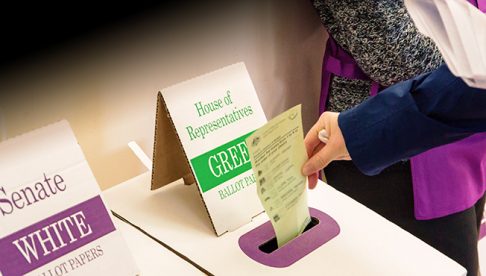 Hand posting ballot in voting booth