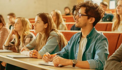 Male university student sitting in lecture theatre