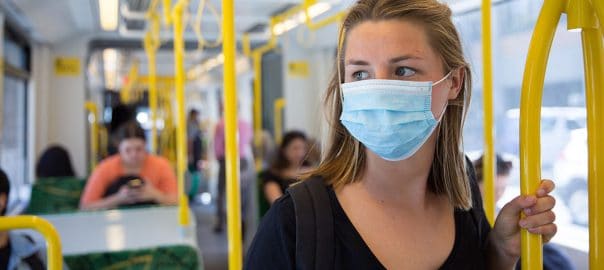 Young woman wearing a face mask on Melbourne tram