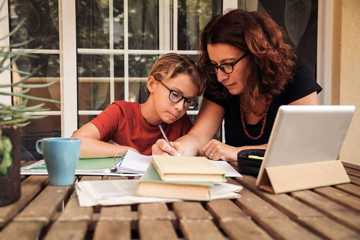 Mother home schooling child with iPad