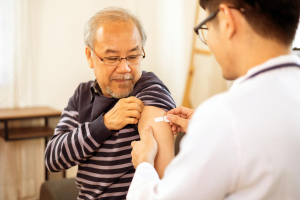 An older Asian man receiving a vaccination